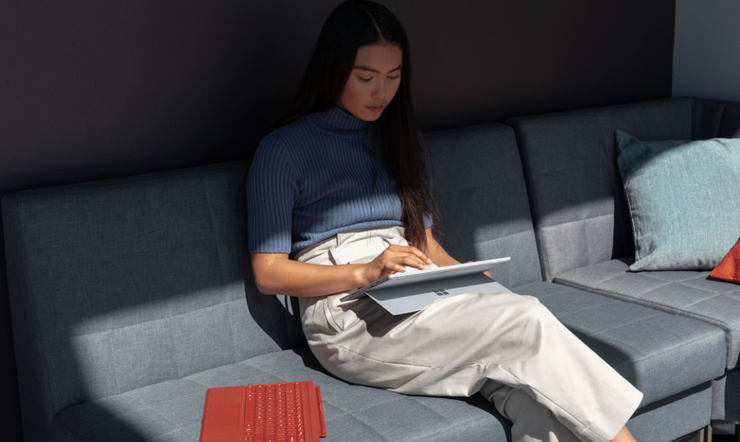Contextual image of woman inside working on Surface Pro 7