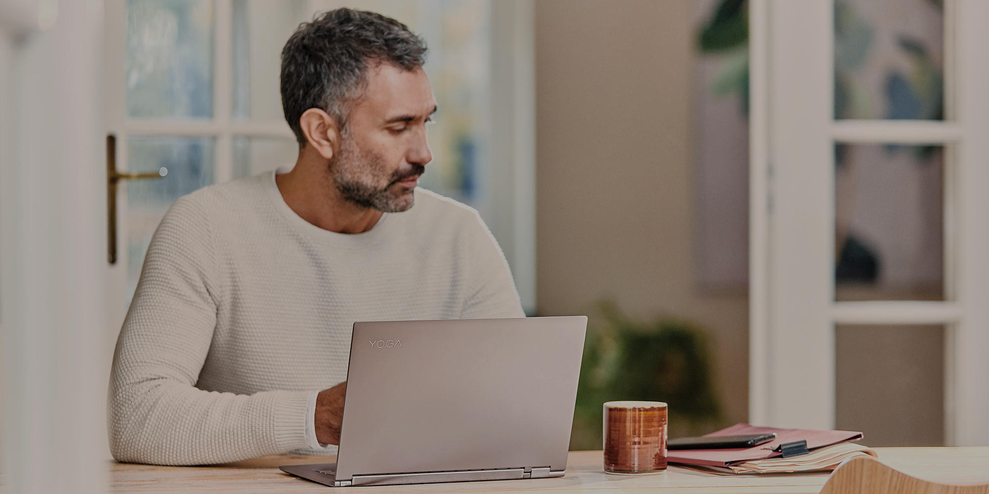 um homem em pé à frente de um computador portátil