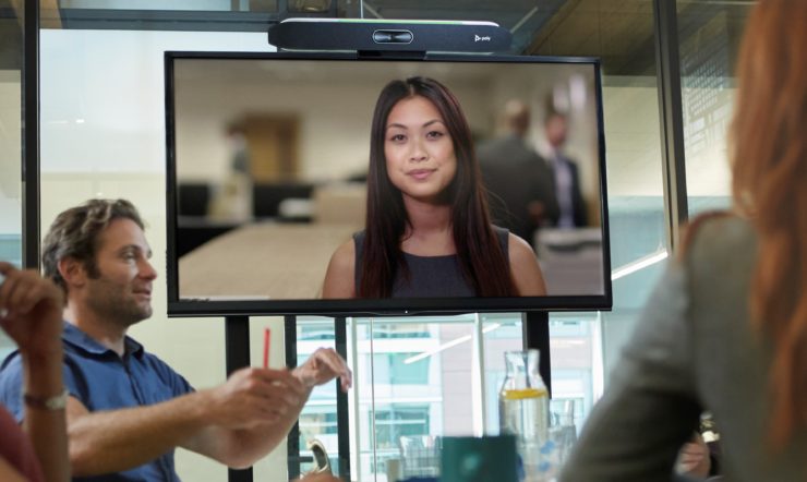 Vrouw op groot scherm tijdens vergadering