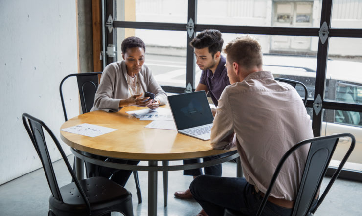una persona seduta a un tavolo utilizzando un computer portatile