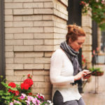 a woman sitting on a sidewalk