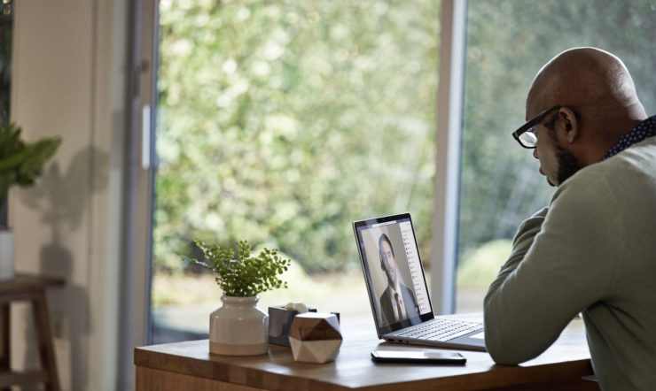 un uomo seduto a un tavolo con un computer portatile