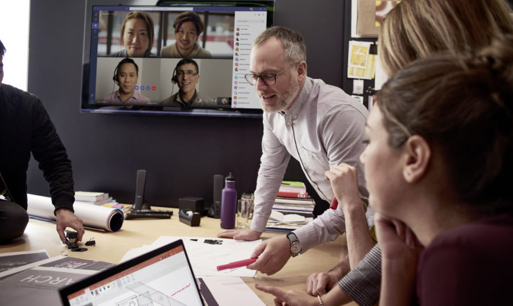 Female/Male small medium business employees collaborating using PowerPoint and Microsoft Teams; collaboration; conference room.
