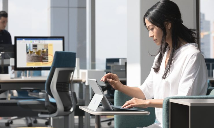 una donna seduta a una scrivania di fronte a un computer