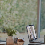 une personne assise à une table utilise un ordinateur portable