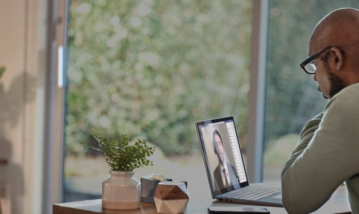 iemand die aan een tafel zit en een laptop gebruikt