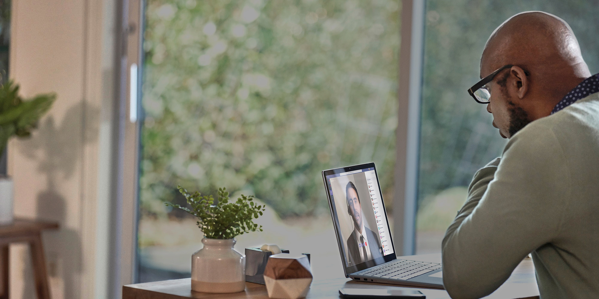 iemand die aan een tafel zit en een laptop gebruikt