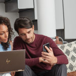 iemand zit aan een tafel en gebruikt een laptop