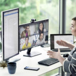 une personne assise à un bureau devant un ordinateur portable