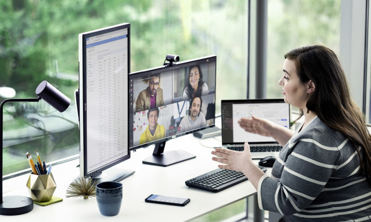 a person sitting at a desk in front of a laptop computer