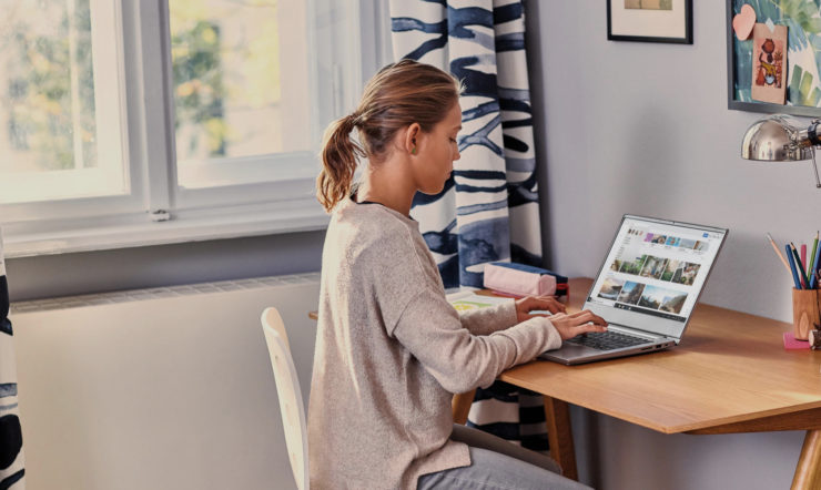 a person sitting at a table using a laptop