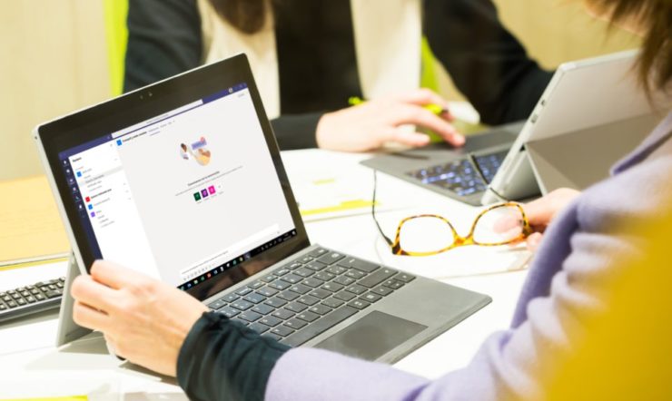 un grupo de personas sentadas en una mesa usando una computadora portátil