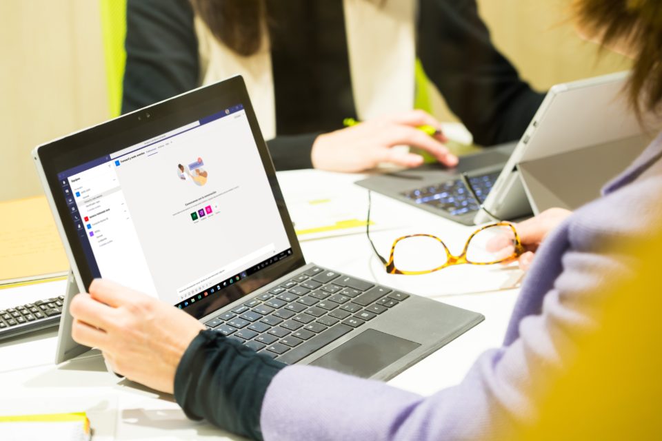 un grupo de personas sentadas en una mesa usando una computadora portátil