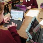 a woman sitting at a table using a laptop