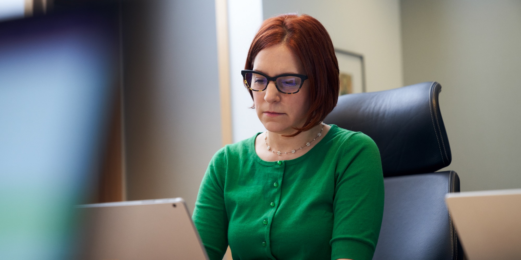 a woman sitting at a table using a laptop computer