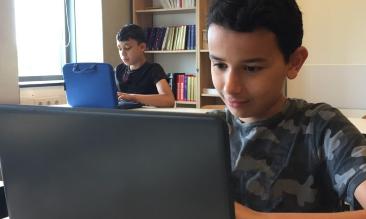 a person sitting in front of a laptop computer