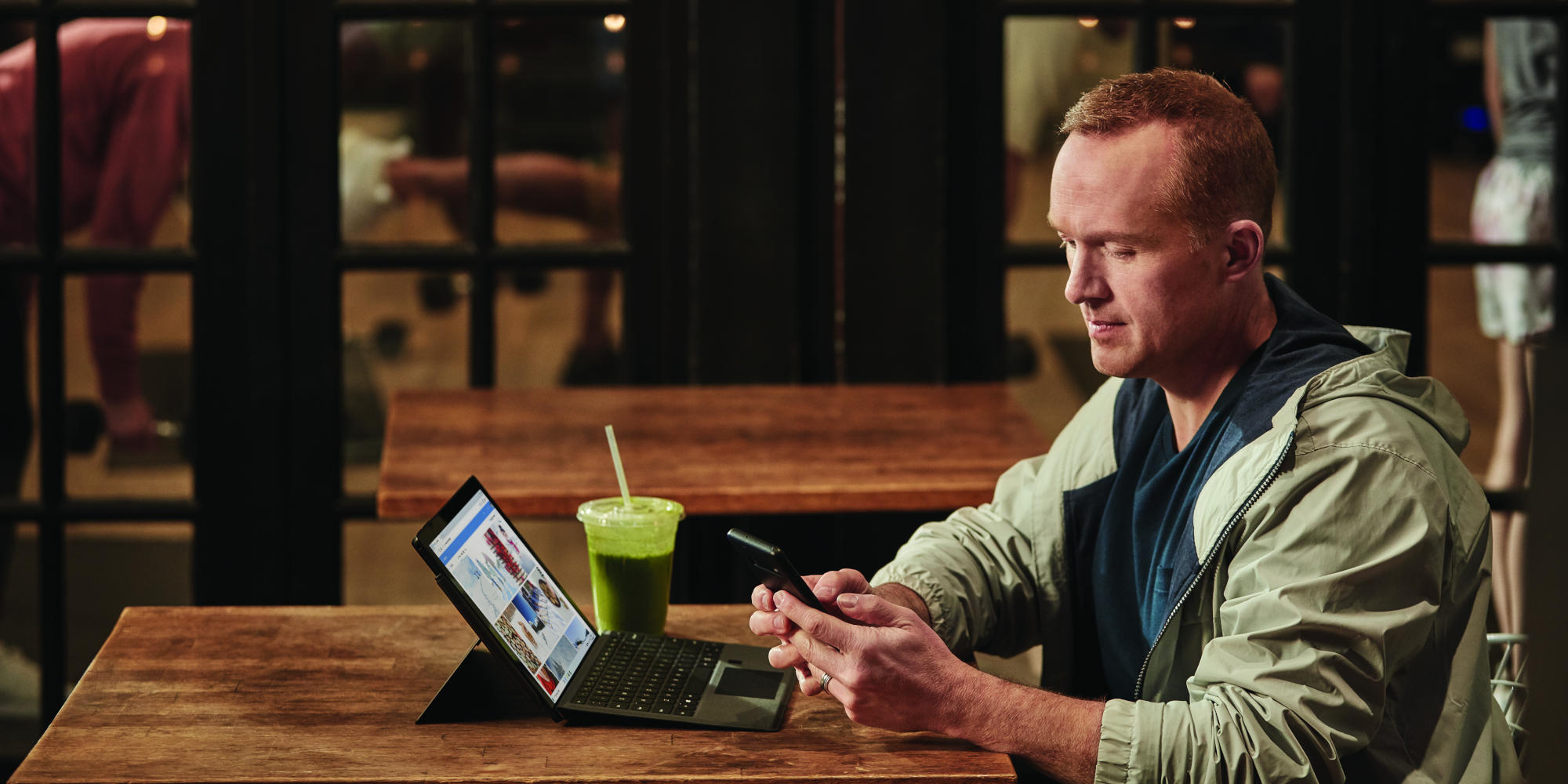 en mand sidder ved et bord og bruger en laptop