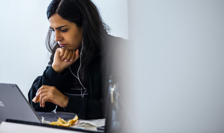 a person sitting at a table using a laptop computer