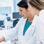 Two female healthcare professionals looking at a tablet