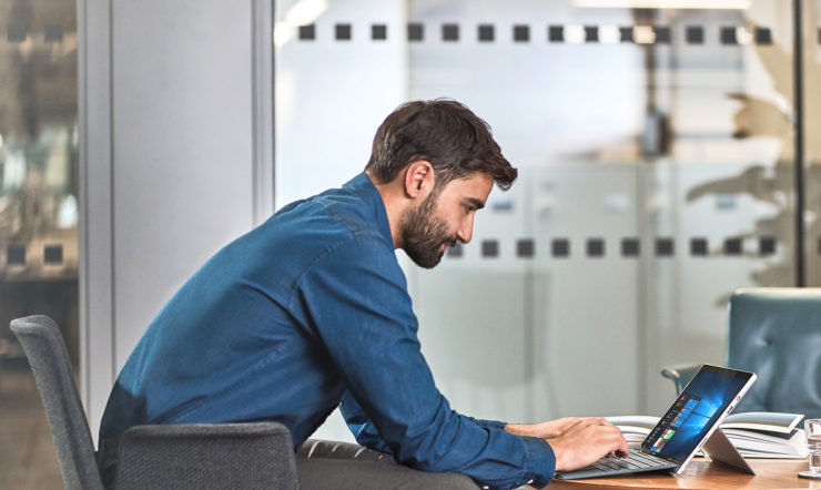 A man sitting at a table using a laptop