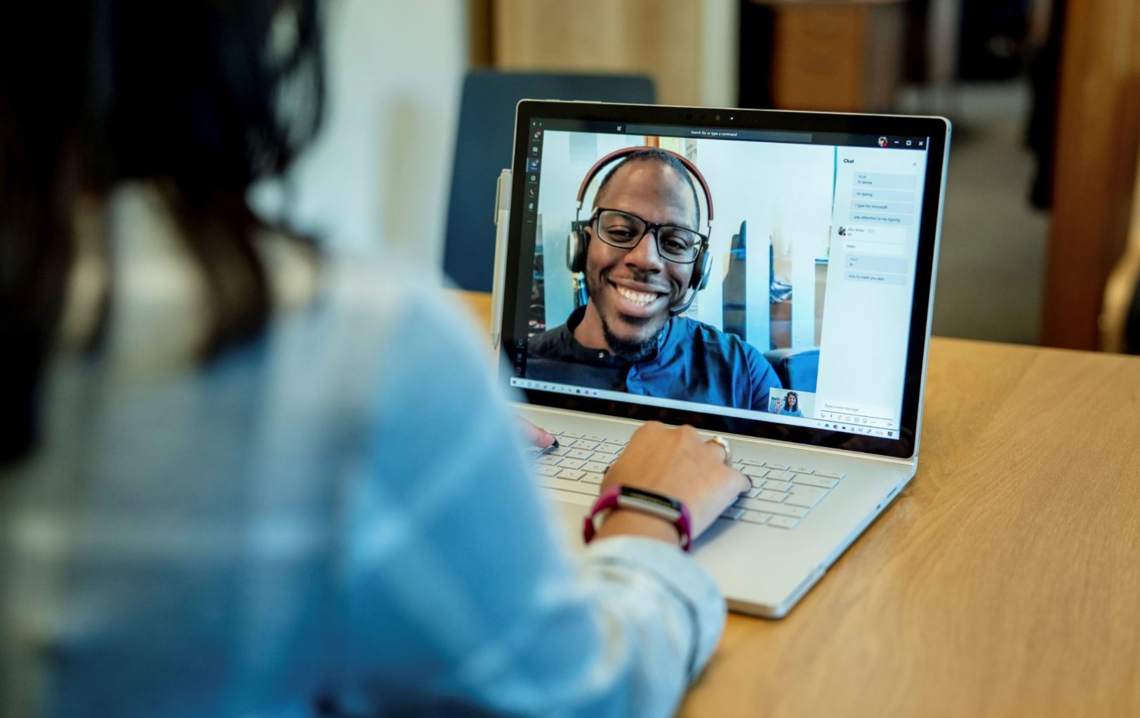 een persoon die een laptopcomputer gebruikt die bovenop een lijst zit