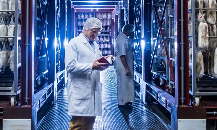 A man standing in front of an industrial food refrigerator