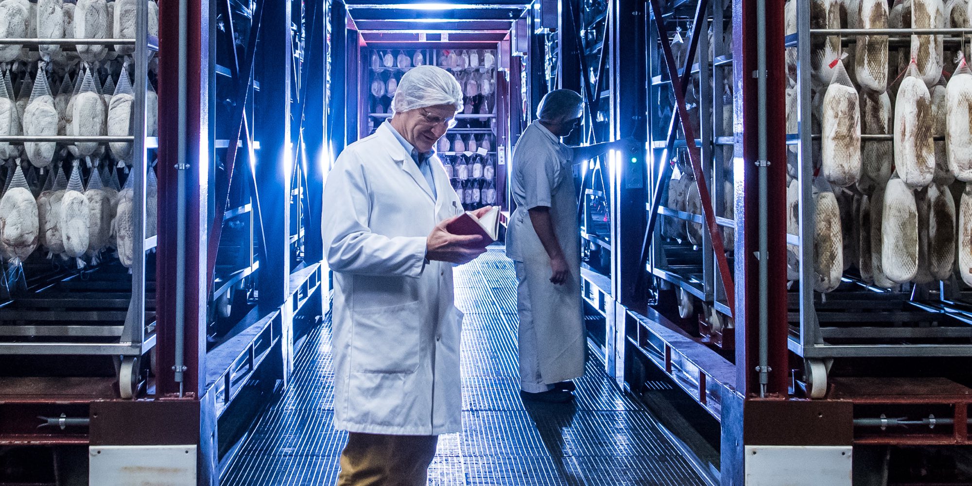 A man standing in front of an industrial food refrigerator