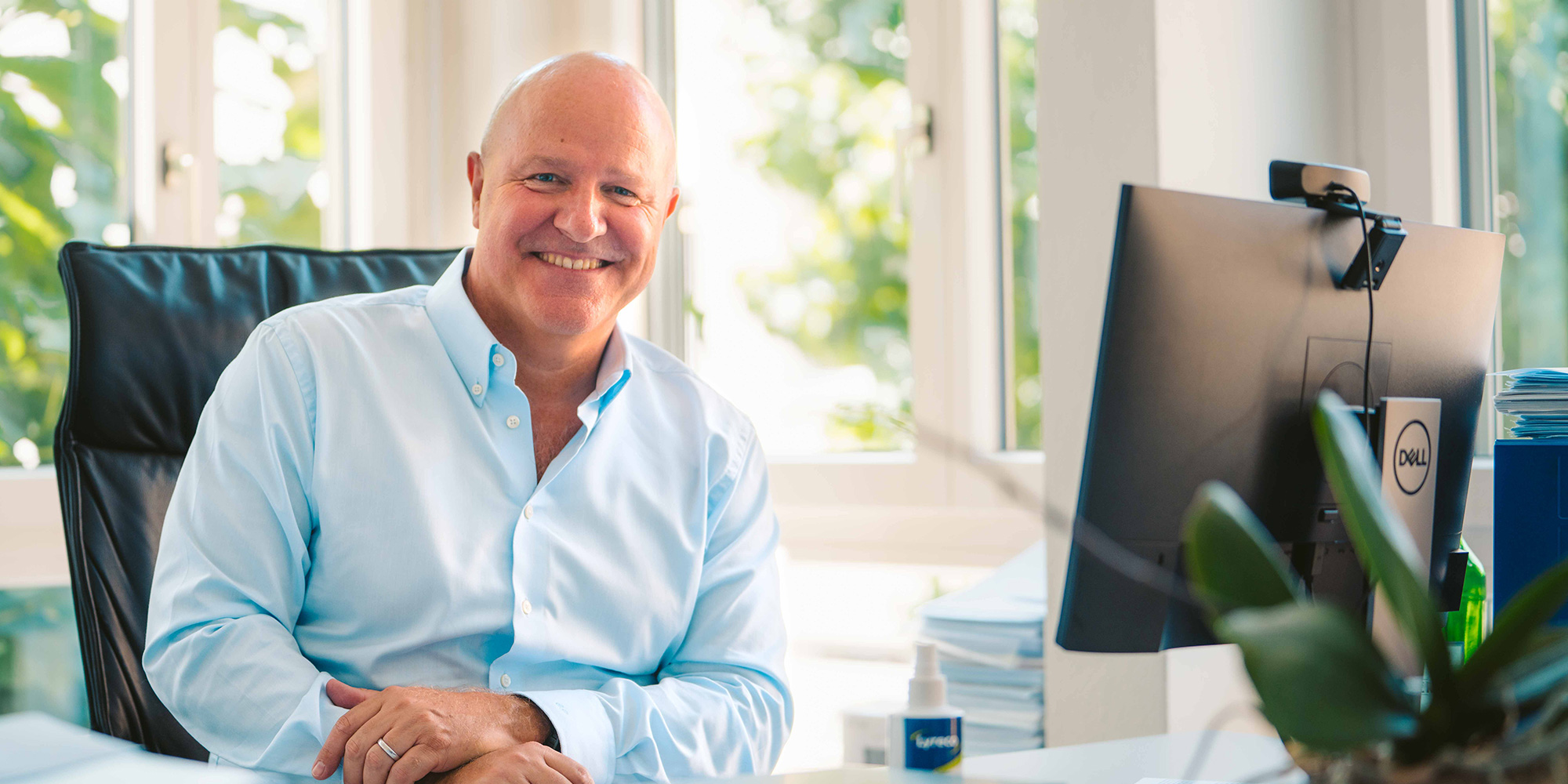 A man sitting down and smiling at the camera