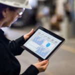a woman holding a tablet in a manufacturing plant