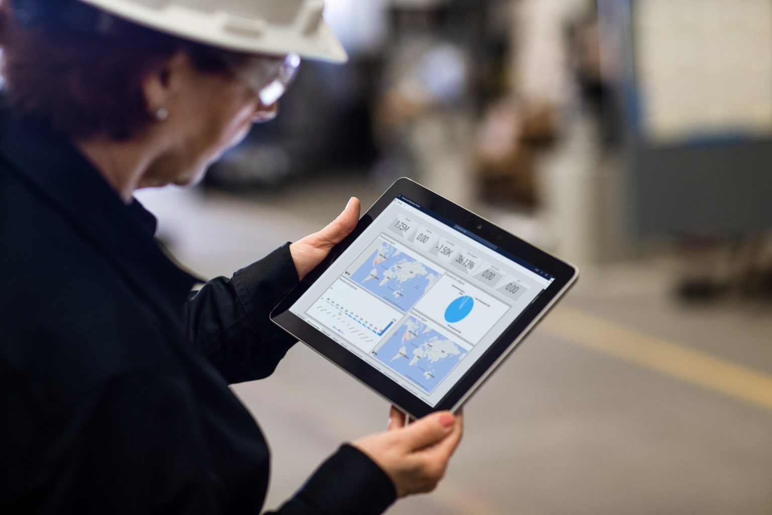 a woman holding a tablet in a manufacturing plant