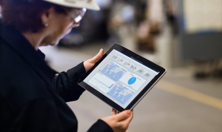 a woman holding a tablet in a manufacturing plant