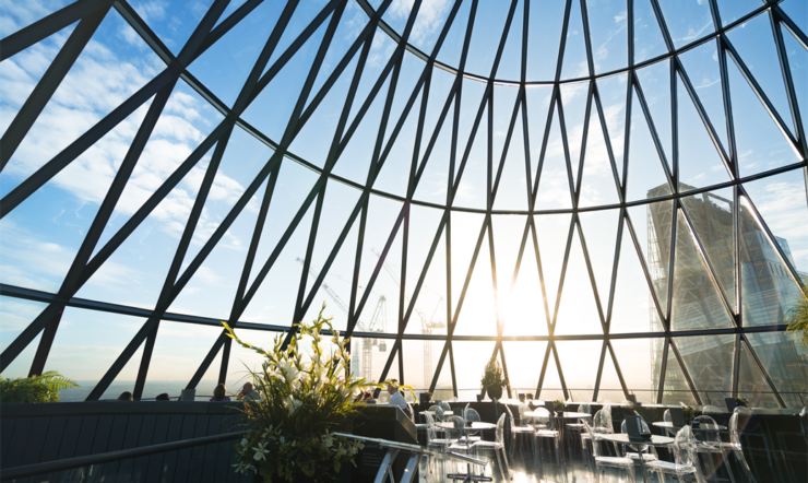 een groot gebouw met een metalen hek met 30 St Mary Axe op de achtergrond