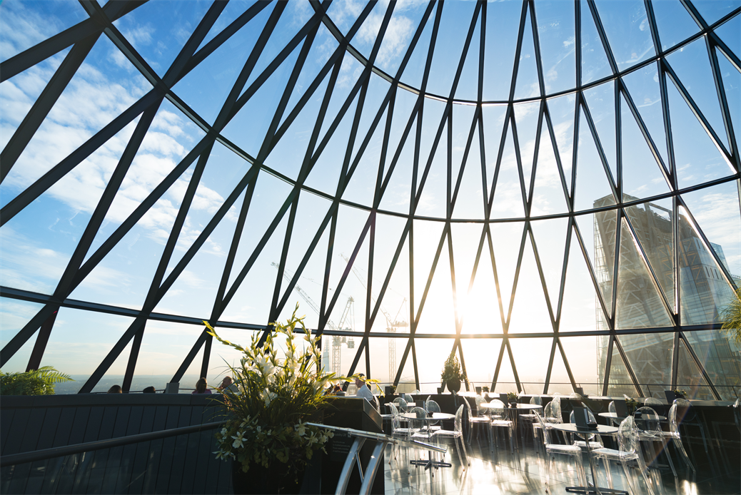 een groot gebouw met een metalen hek met 30 St Mary Axe op de achtergrond