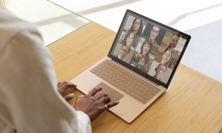 Marisa Blair die een laptopcomputerzitting bovenop een houten lijst gebruikt