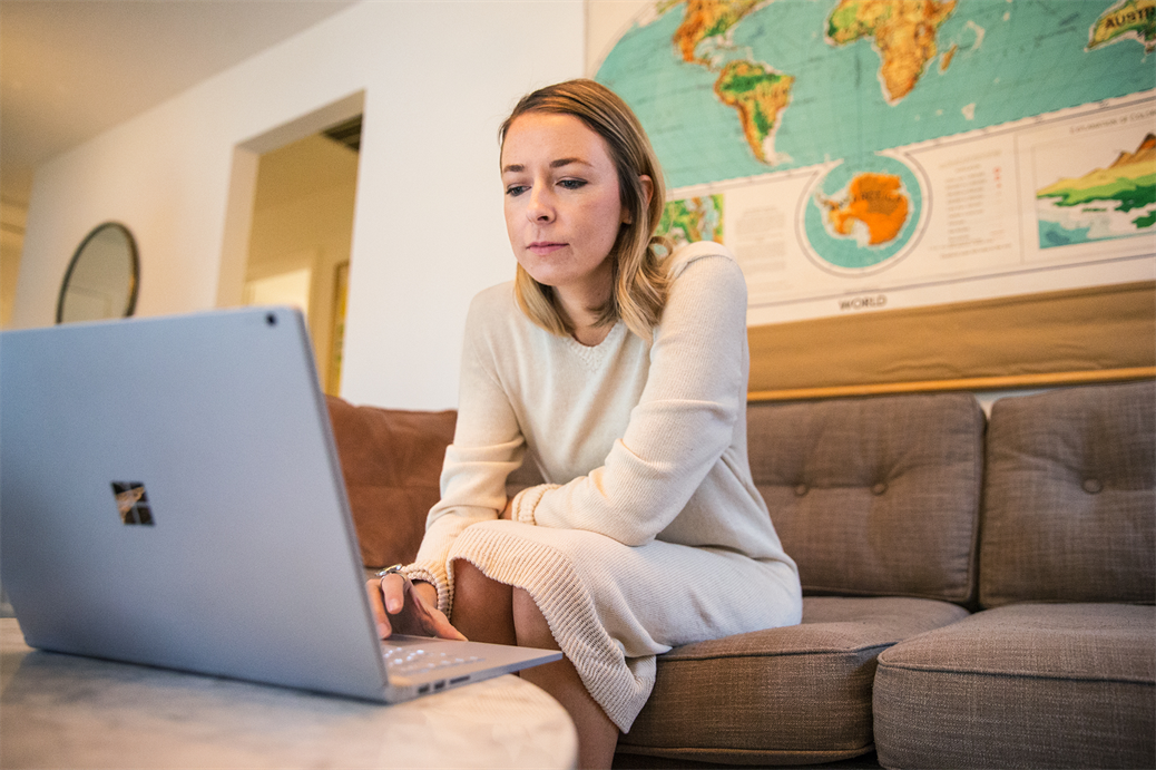 een vrouwenzitting bij een lijst die laptop gebruikt