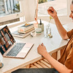 a woman sitting at a table in front of a laptop