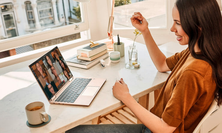 a woman sitting at a table in front of a laptop