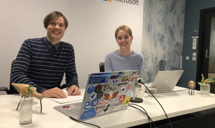 en gruppe mennesker som sitter ved et bord foran en bærbar PC