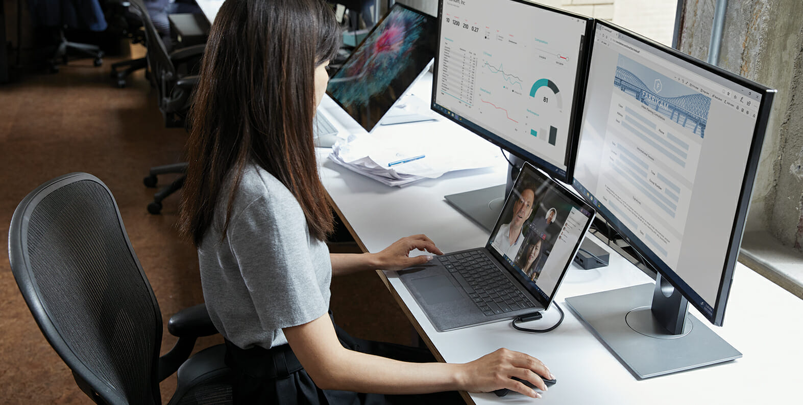 uma pessoa sentada em uma mesa na frente de um computador portátil