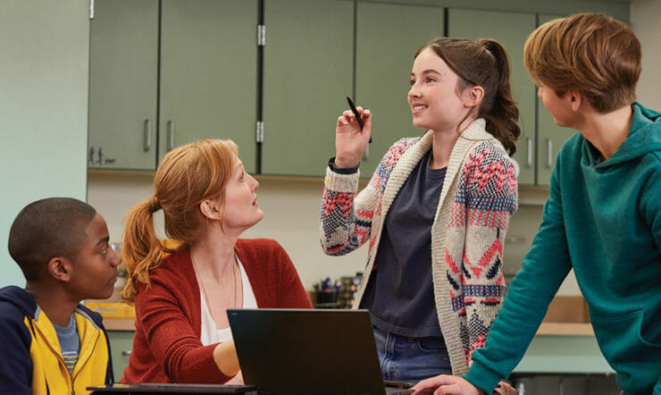 Eden Campbell et al. olhando para um laptop