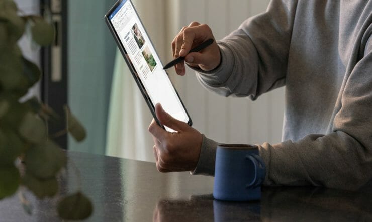 a man holding a Surface Pro in his hand