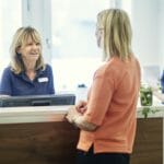 A woman working in healthcare talking to another woman