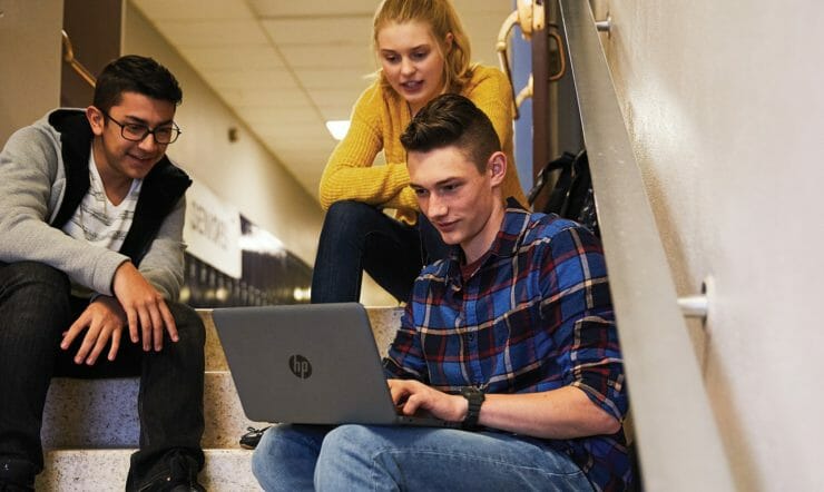 a group of people looking at a laptop
