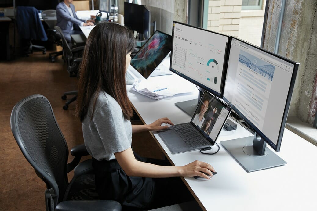 een vrouwenzitting bij een bureau voor een laptopcomputer