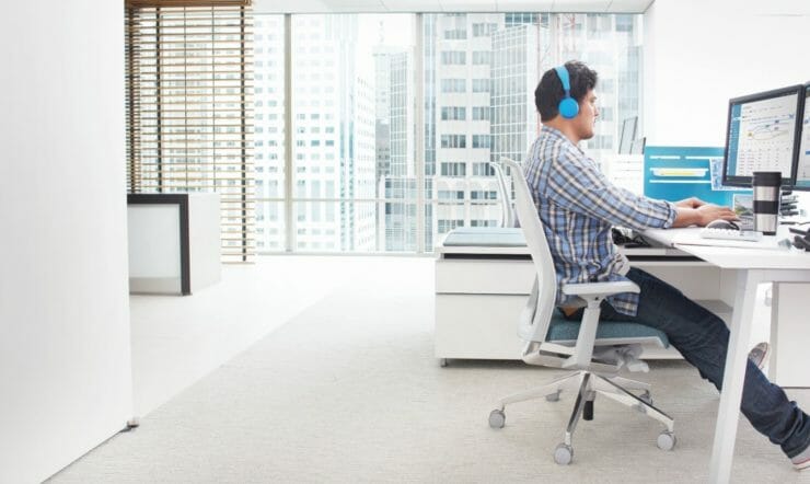 een mens die bij een bureau in een ruimte zit