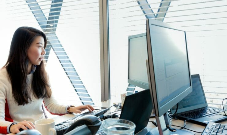 a woman sitting at a desk using a computer