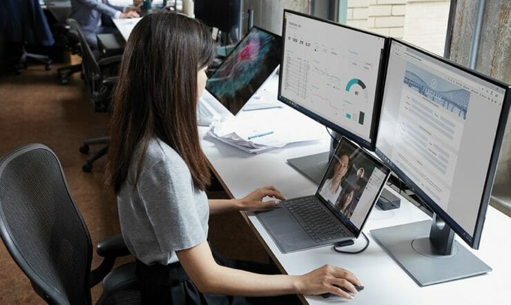 en kvinde sidder ved et skrivebord foran en bærbar computer