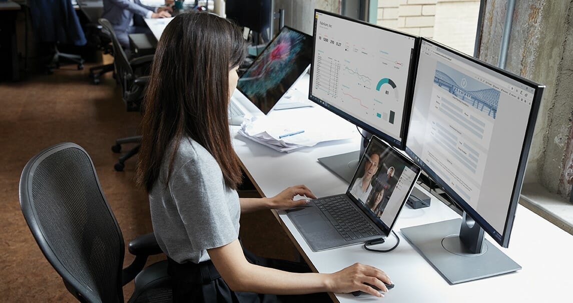 a woman sitting at a desk in front of her laptop computer