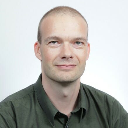 en mann som smiler for kameraet