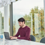 a person sitting at a table using a laptop